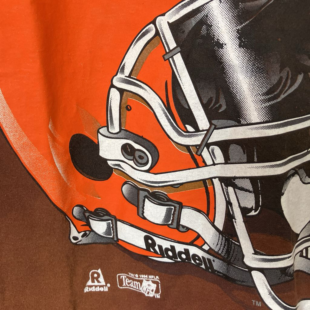 Close-up of a football helmet with 'Riddell' branding on an orange and brown background