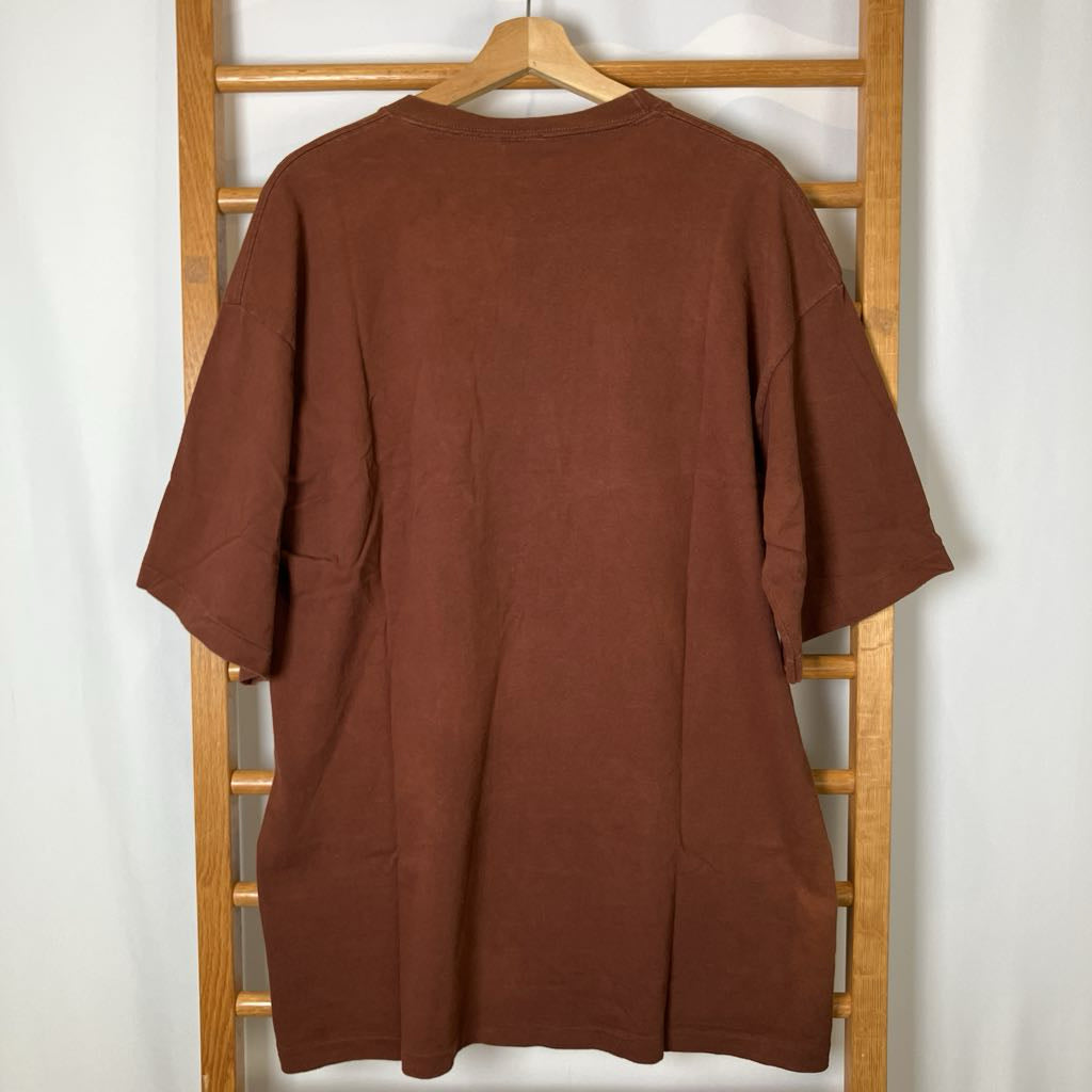 Brown shirt on a hanger against a white wall