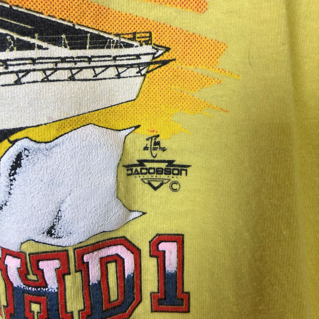 Embroidered design on a yellow fabric with a bear, text, and a logo.