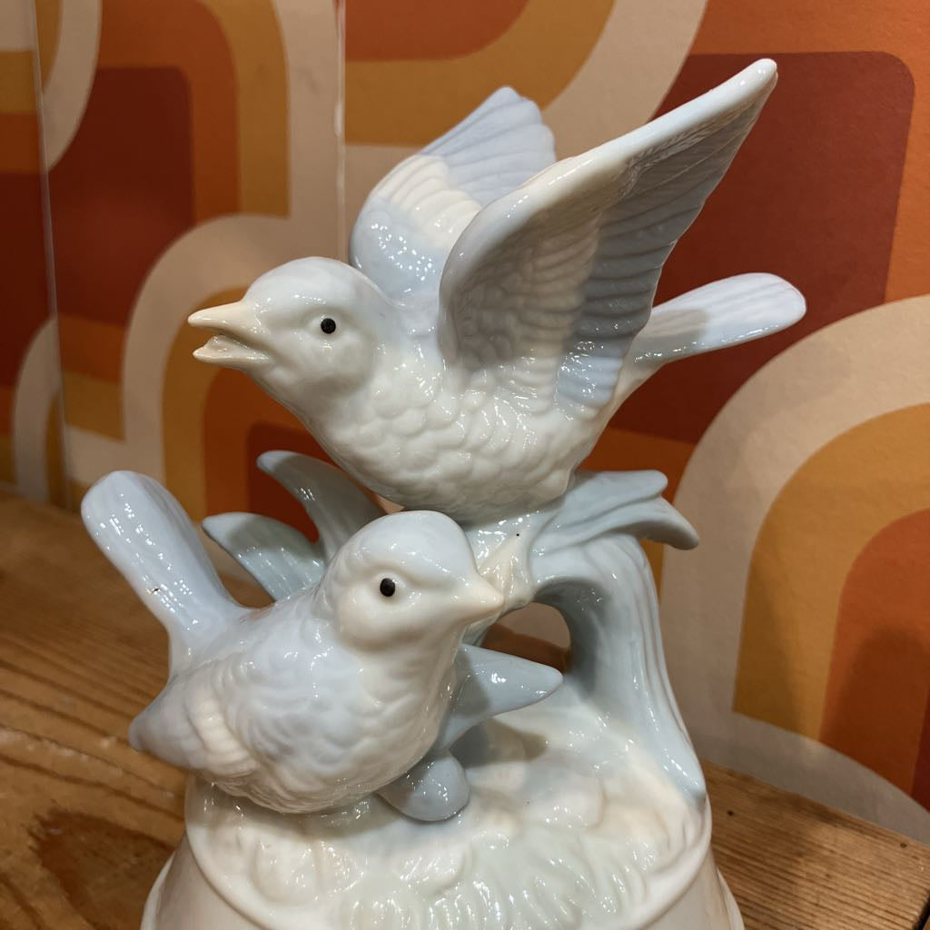 White ceramic birds on a decorative background