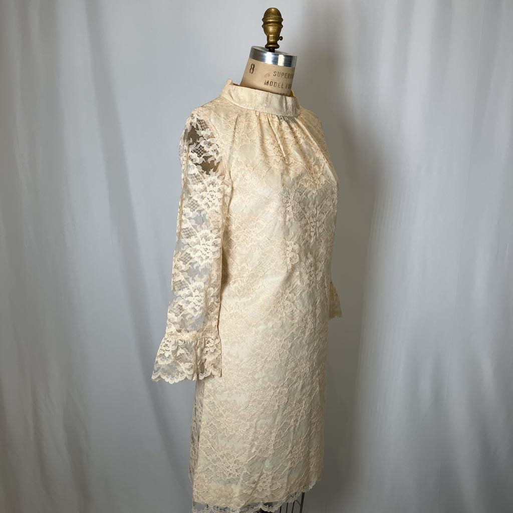 Vintage lace dress on a mannequin against a plain background