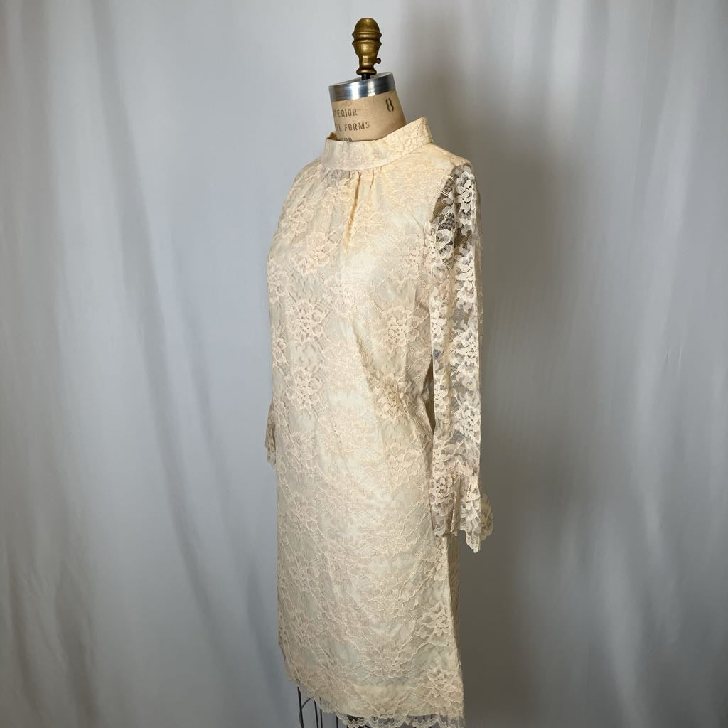 Vintage lace dress on a mannequin against a plain background