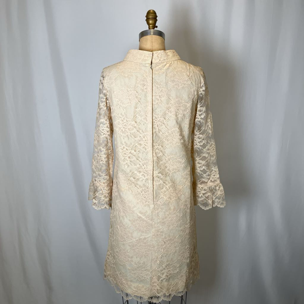 White lace dress on a mannequin against a plain background