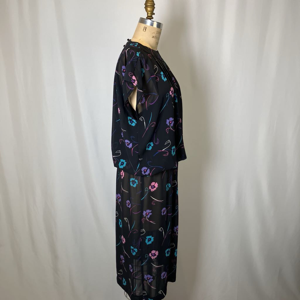 Black floral-patterned dress on a mannequin against a plain background