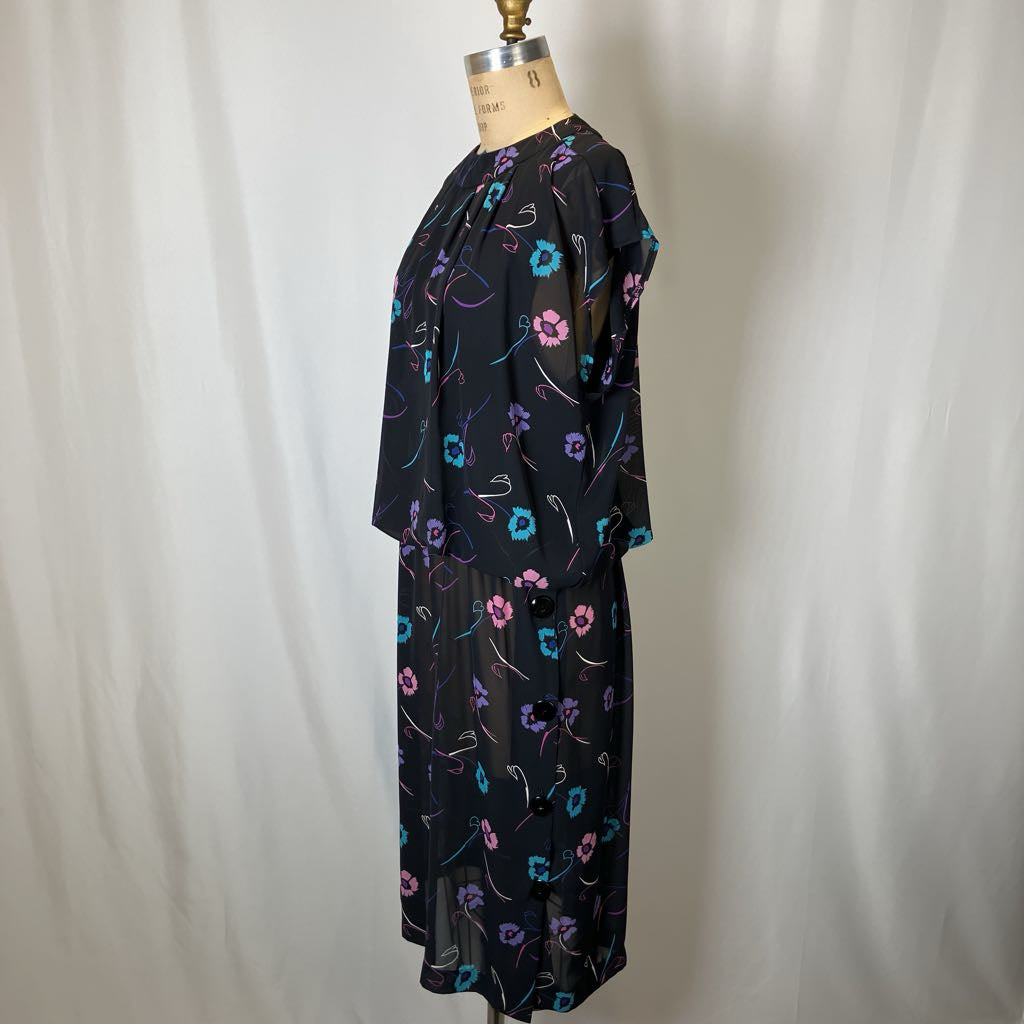 Black dress with colorful floral pattern on a mannequin against a white background