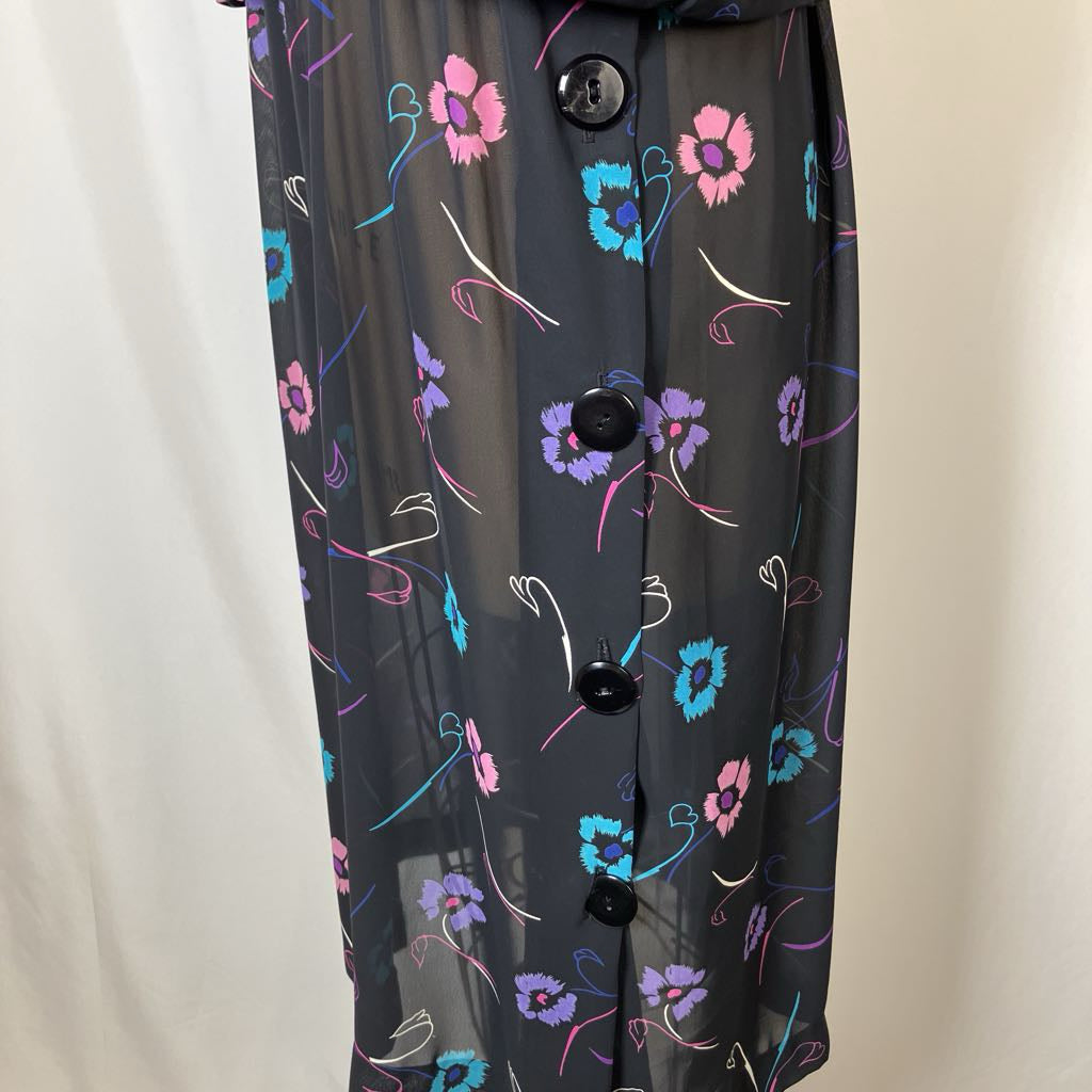 Black floral patterned shirt with buttons on a plain background