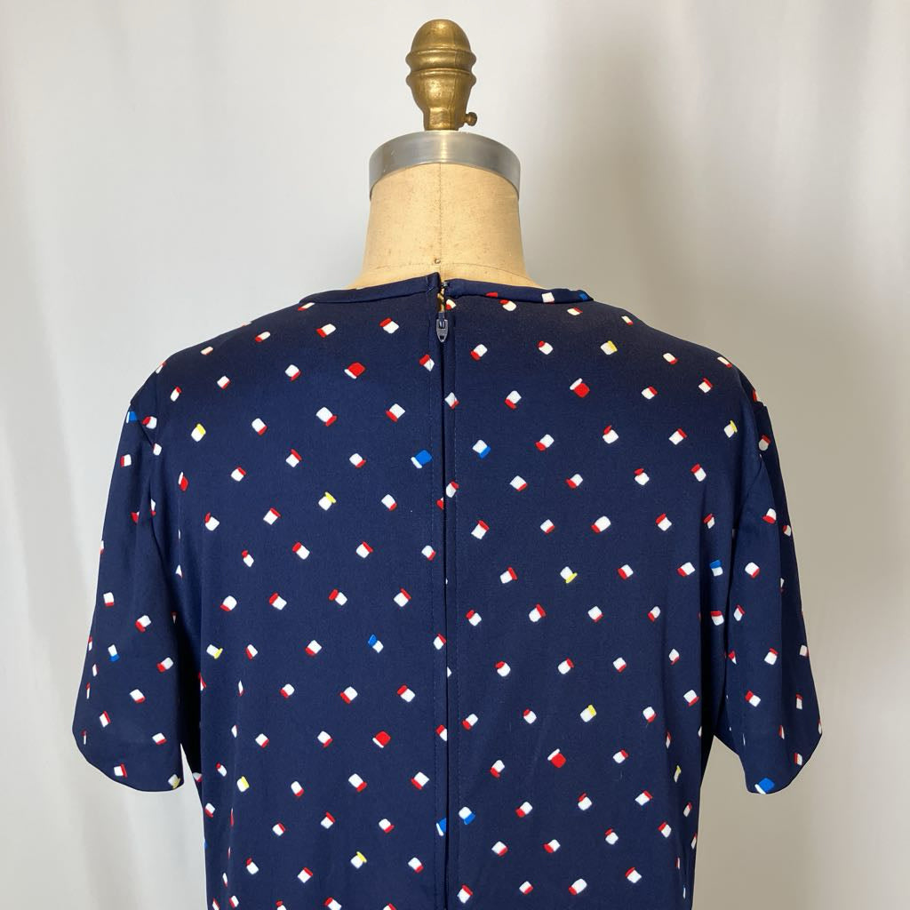 Navy blue blouse with colorful geometric pattern on a mannequin against a plain background