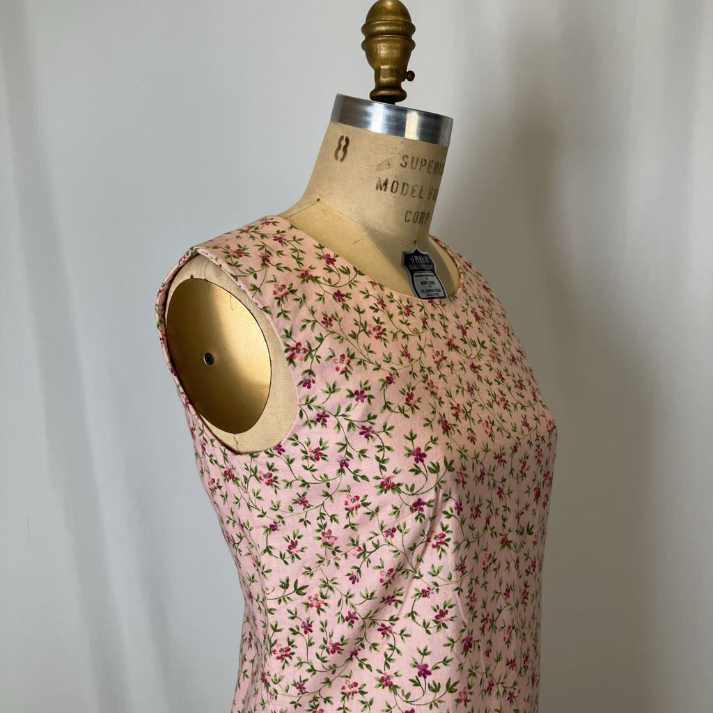 Mannequin wearing a pink floral dress against a plain background