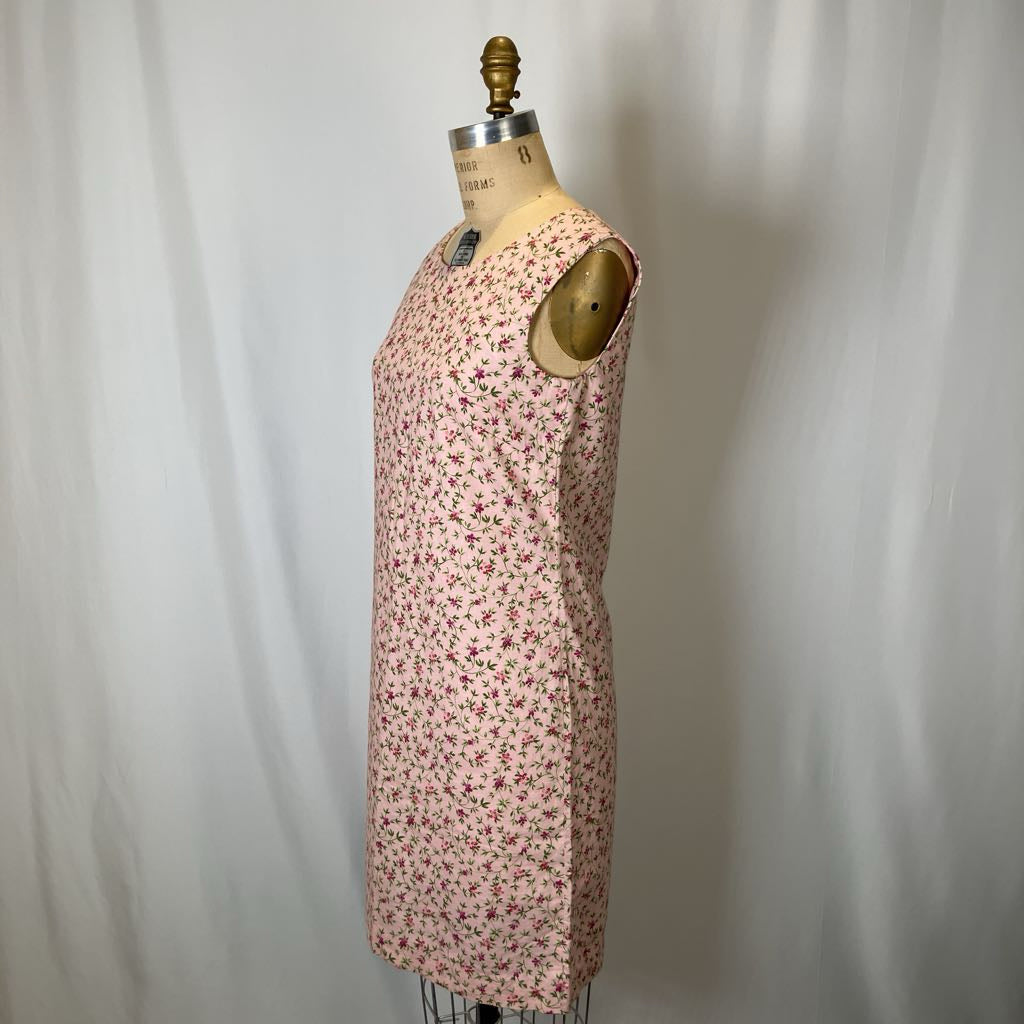 Pink floral dress on a mannequin against a plain background