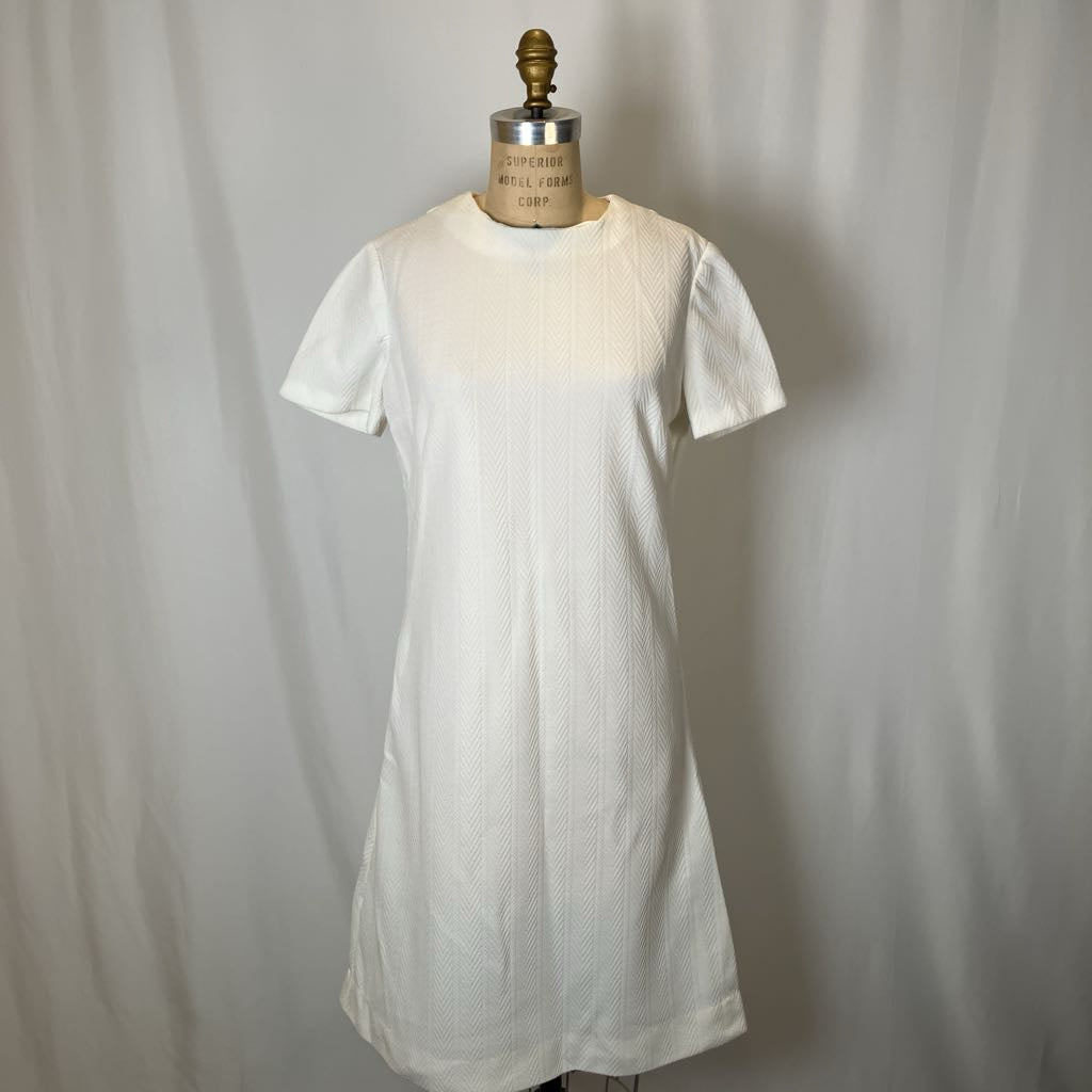 White dress on a mannequin against a plain background