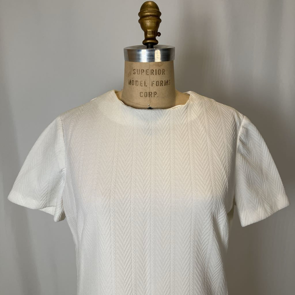 White textured shirt on a mannequin with 'Superior Model Forms Corp' label.