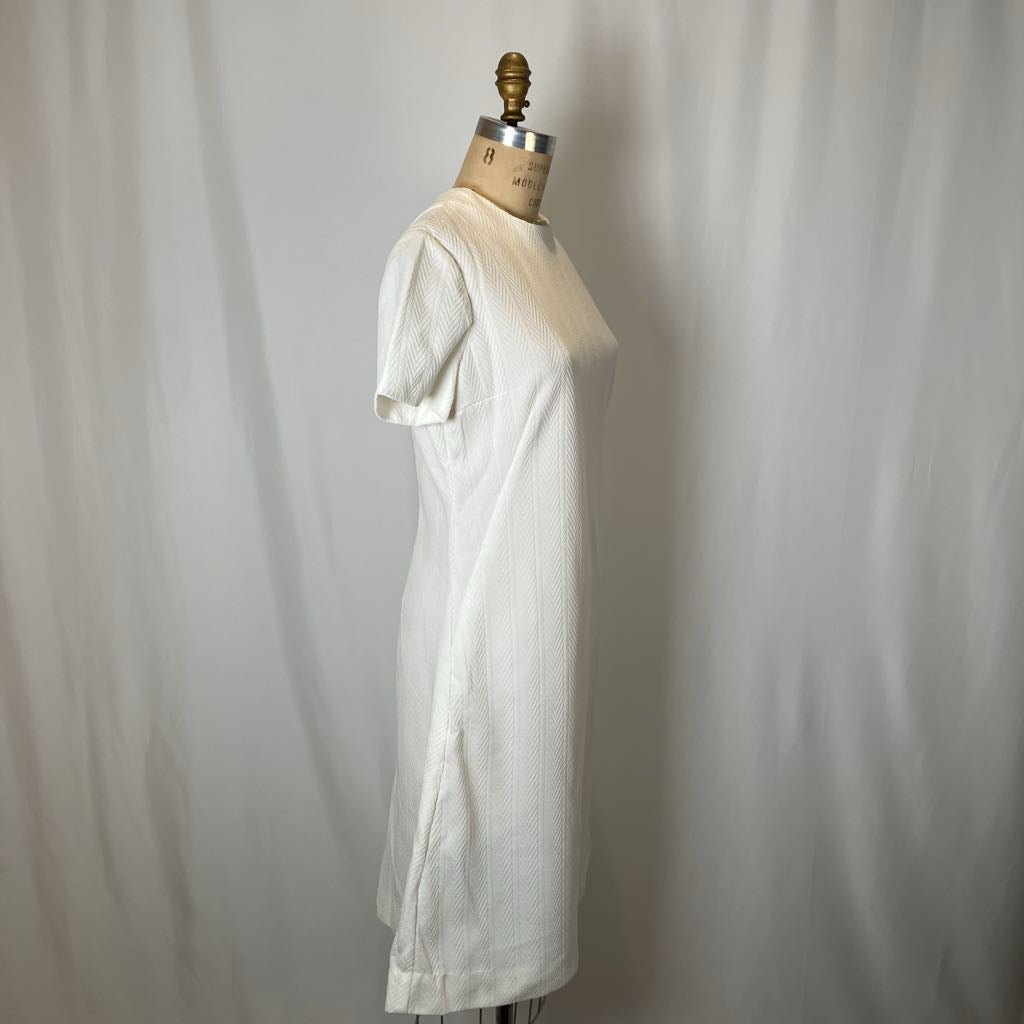White dress on a mannequin against a plain background