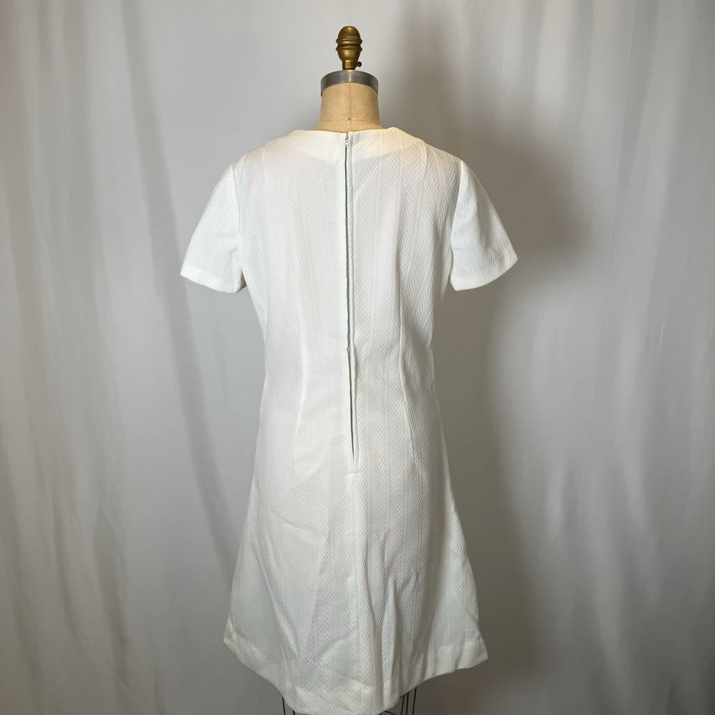 White dress on a mannequin against a plain background
