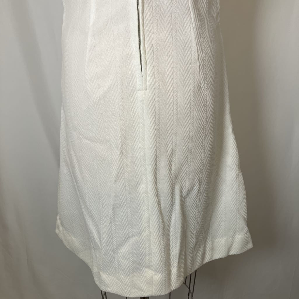 White textured dress on a mannequin against a plain background