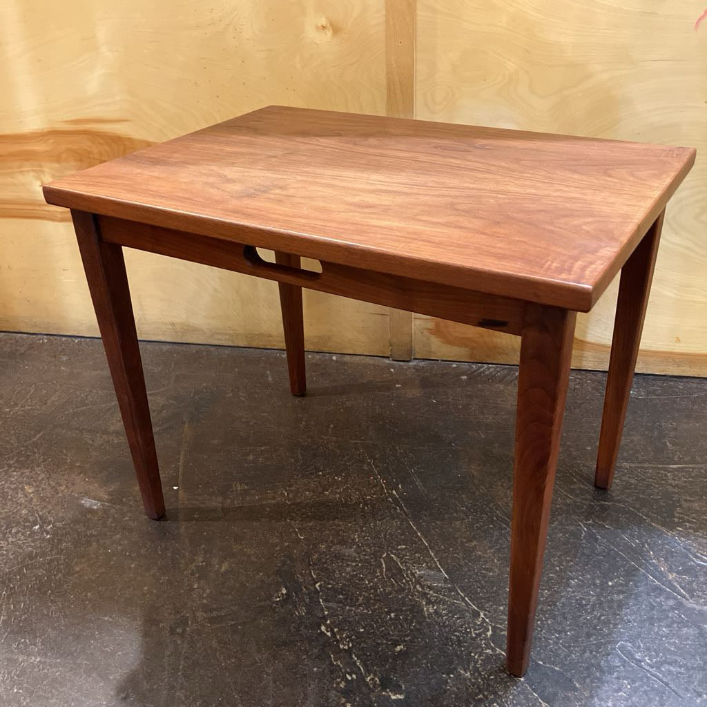 Wooden table on a dark floor with a light wooden wall background