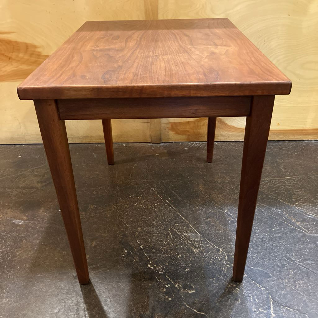Wooden side table against a plain background