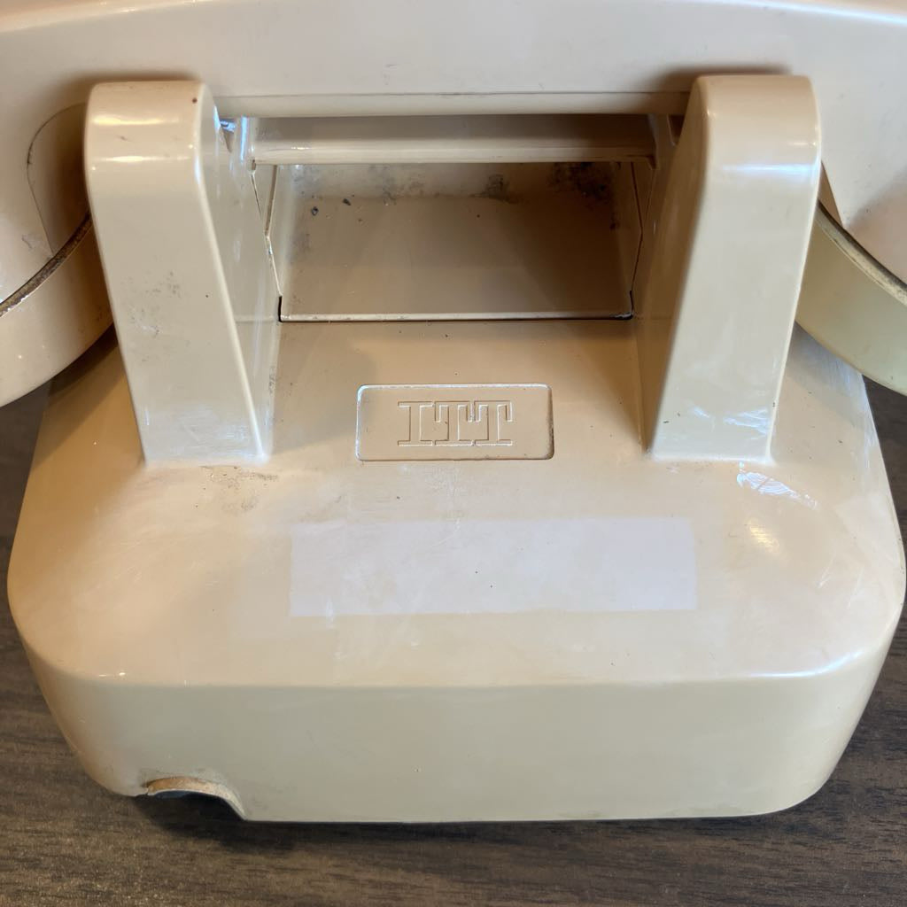 Beige telephone with a visible brand logo on a wooden surface