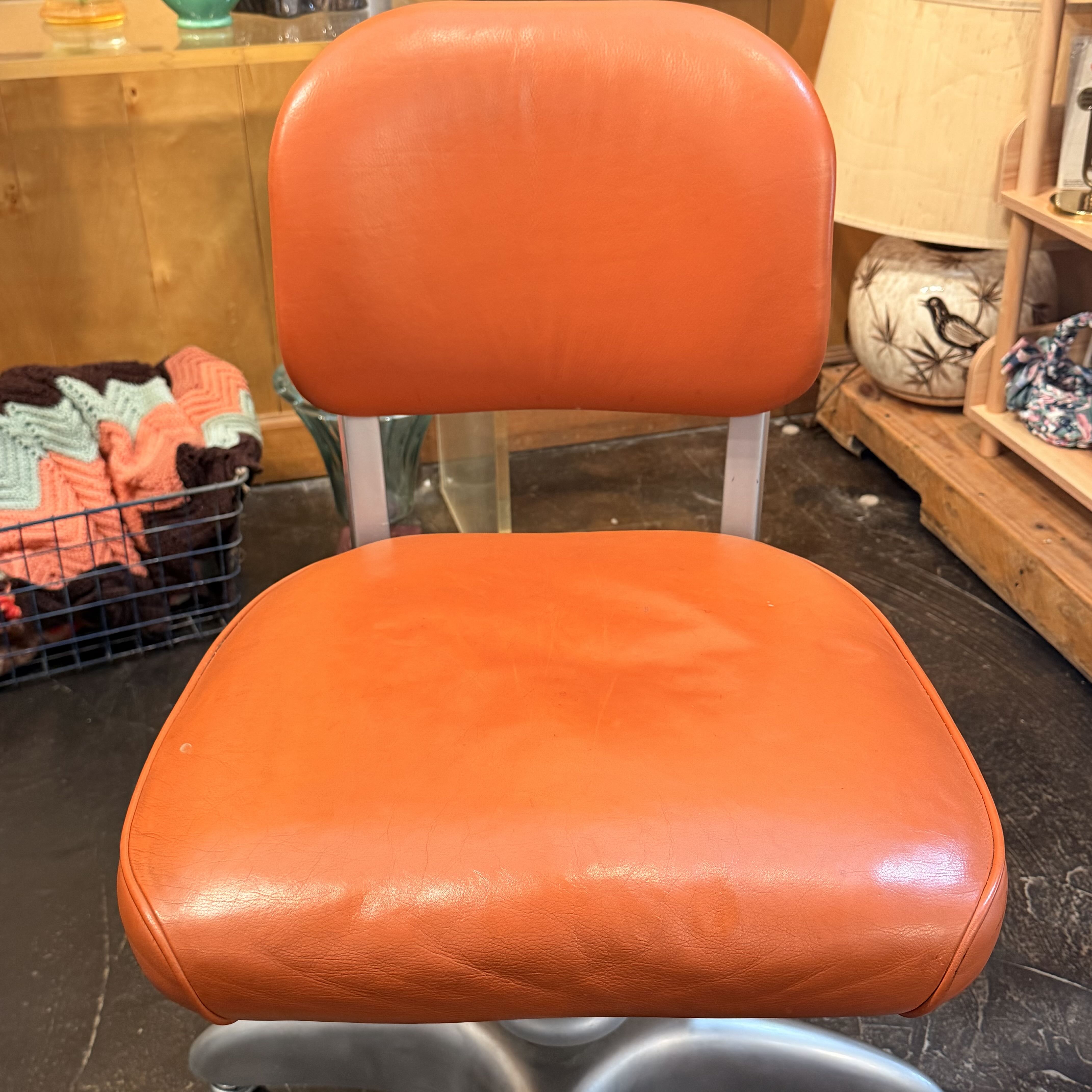 Orange swivel chair with metal silver detailing