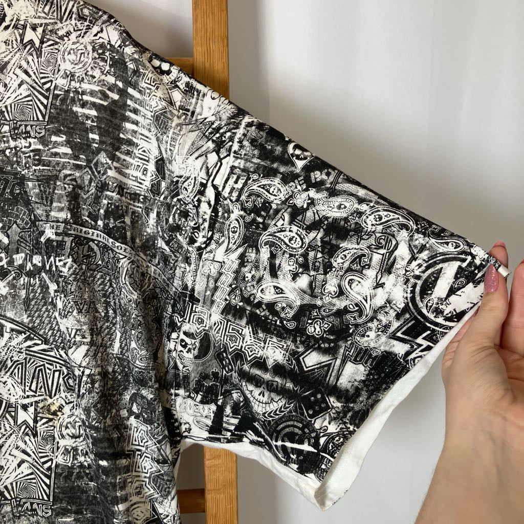 Black and white patterned fabric held by a hand against a neutral background