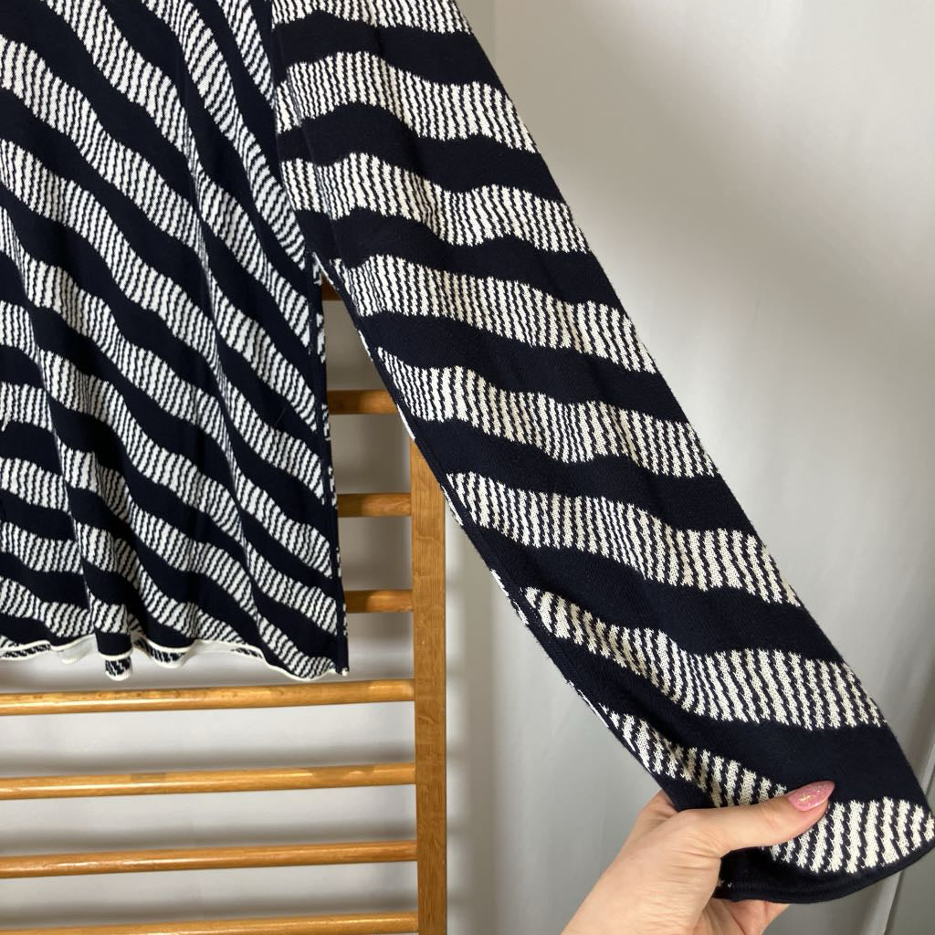 Black and white striped fabric draped over a wooden rack with a neutral background