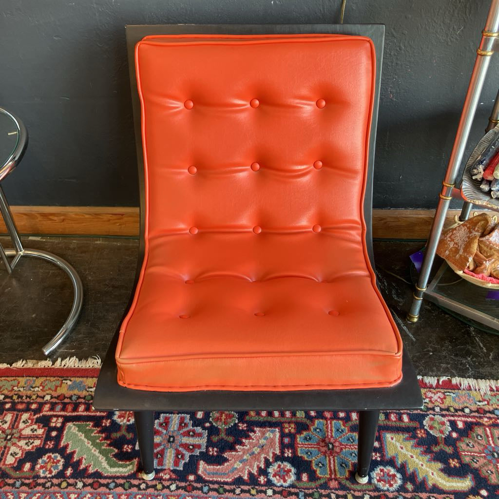 Orange mcm tufted vinyl scoop chair with walnut wood frame  that has been painted black 