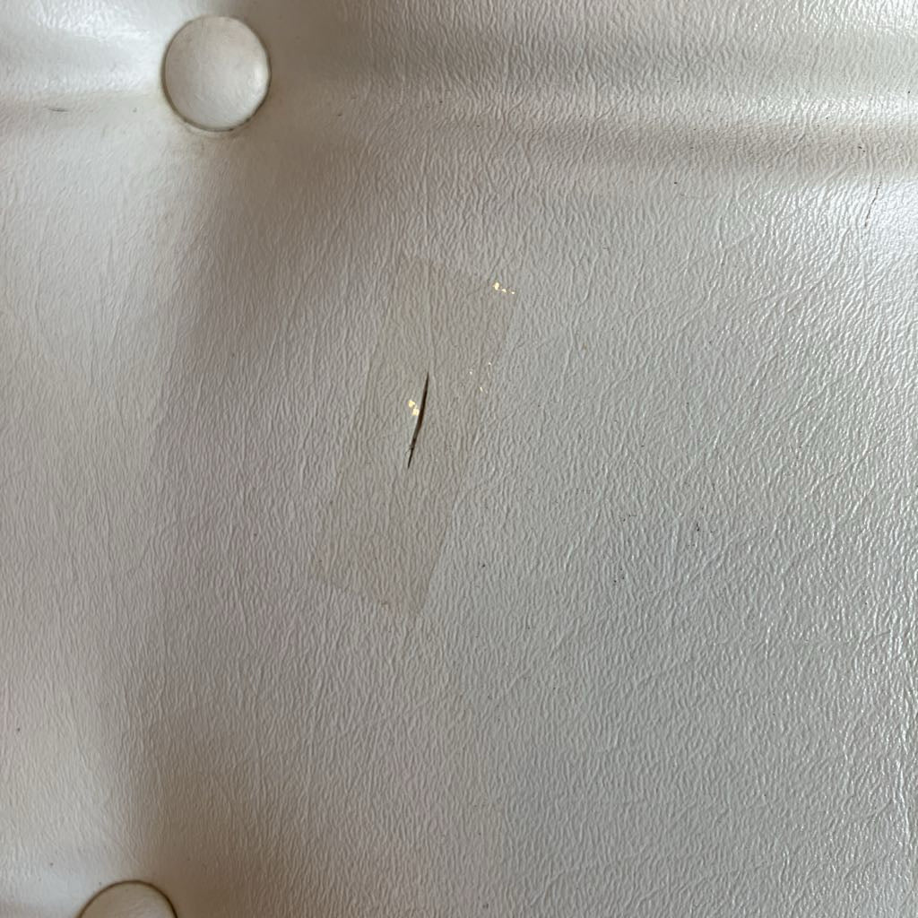 One small tear in the vinyl on the white chair