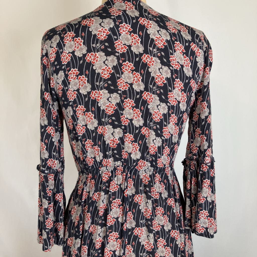 A long-sleeve floral dress displayed on a mannequin, featuring a navy blue base with a red and gray floral pattern.