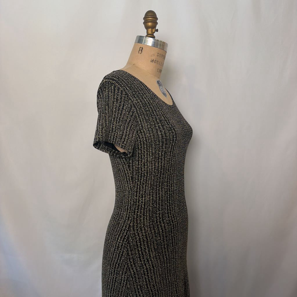 A short-sleeve ribbed knit dress in a dark gray and black marled pattern, displayed on a vintage wooden dress form mannequin against a white fabric backdrop.