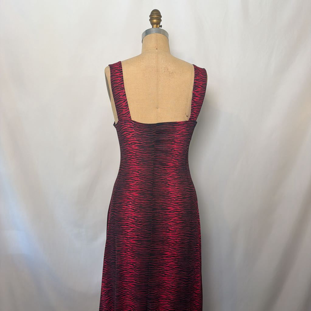 A sleeveless, scoop-neck maxi dress with a textured, wavy pattern in deep red and black, displayed on a beige dress form mannequin against a white fabric backdrop.