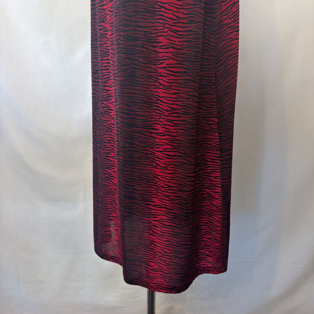 A red and black zebra-print midi skirt displayed on a dress form against a white fabric backdrop.