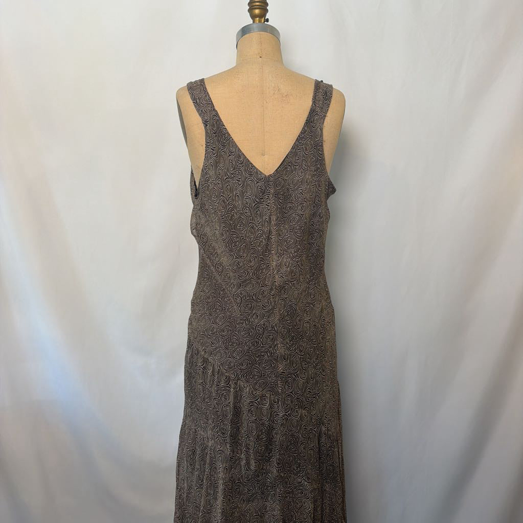 A sleeveless V-neck maxi dress in a textured brown fabric, displayed on a dress form mannequin against a white fabric backdrop.