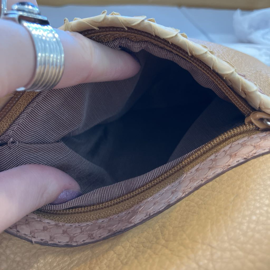 Close-up of a woven leather clutch or small handbag being opened by a hand, showing the interior lining and zipper.