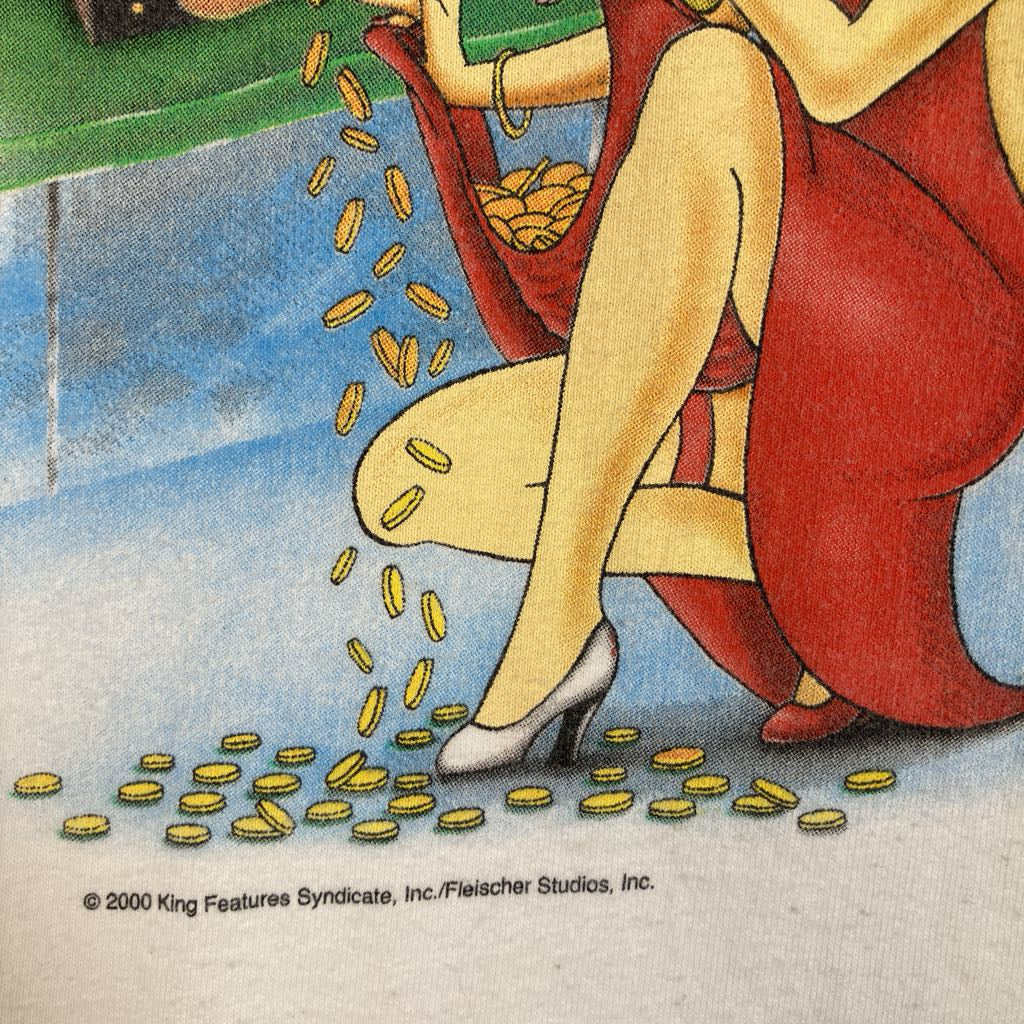 A cropped vintage-style illustration showing a seated woman in a red dress pouring gold coins from a red bag onto the floor. A visible copyright line reads '2000 King Features Syndicate, Inc.