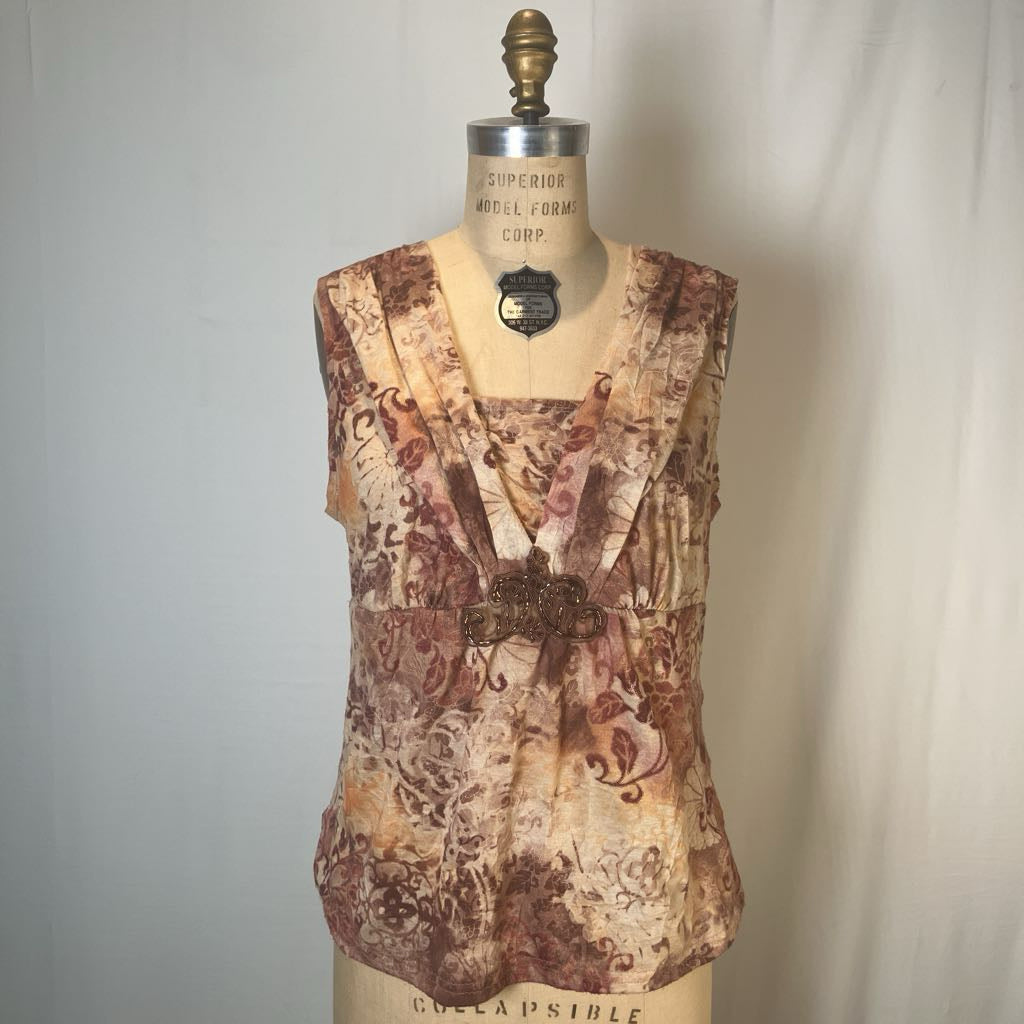 A sleeveless V-neck blouse with a brown and beige floral pattern, displayed on a vintage-style dress form mannequin against a light gray fabric backdrop.