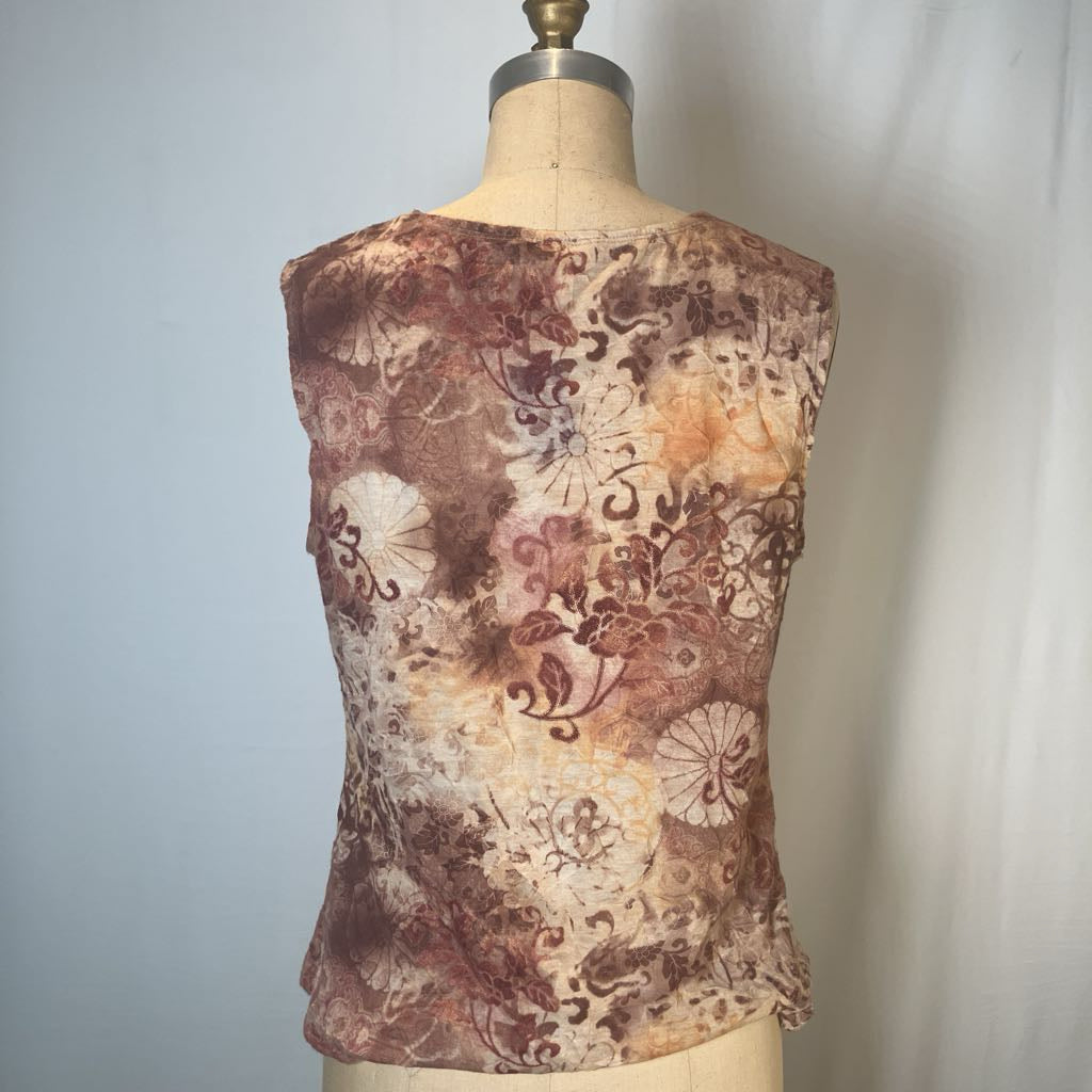 A sleeveless top with an abstract floral and swirl pattern in brown, beige, and rust tones, displayed on a cream-colored dress form mannequin against a light gray fabric backdrop.