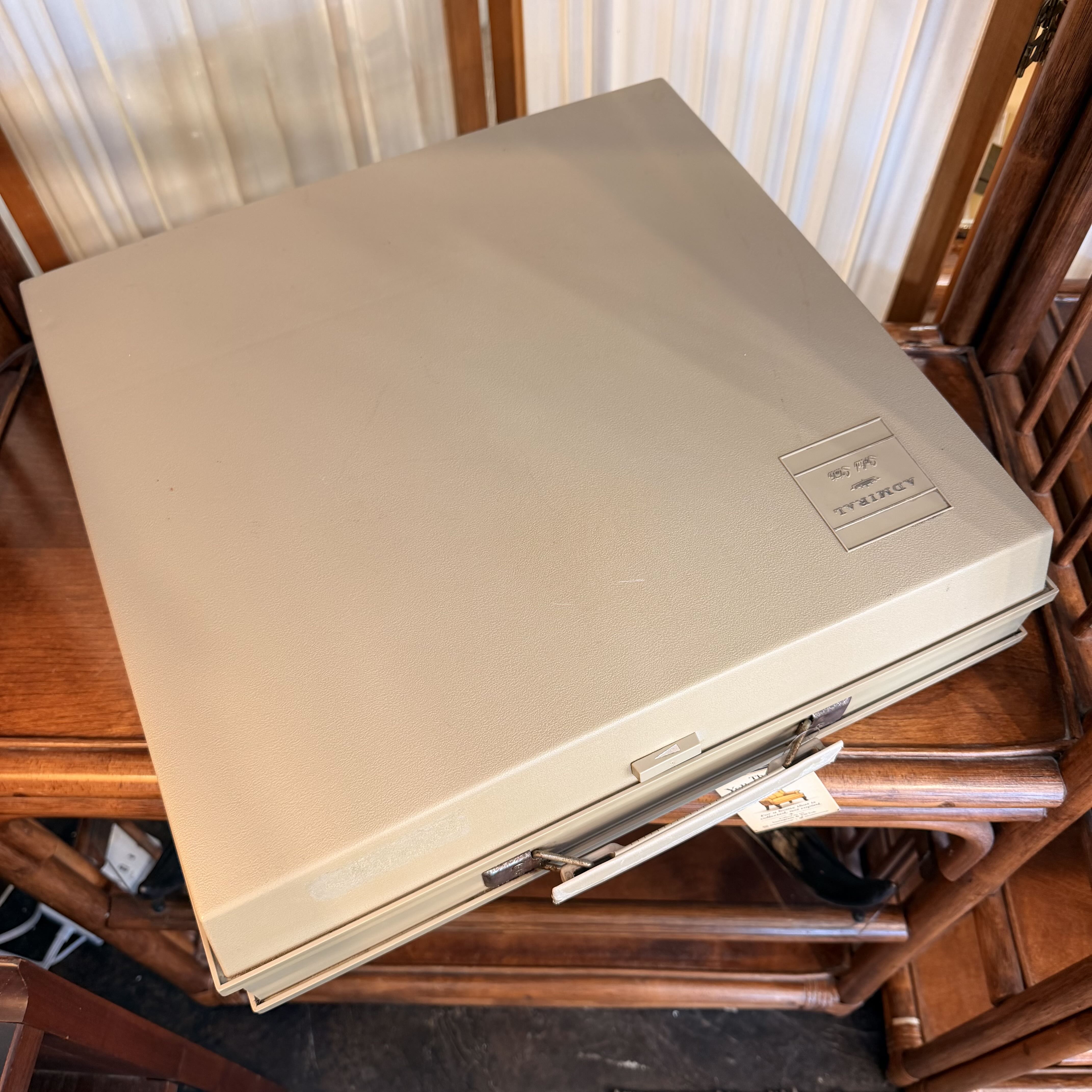A beige vintage Sony VHS tape cover case resting on a wooden table, with a tape partially inserted and a small Sony logo plaque visible on the top right.