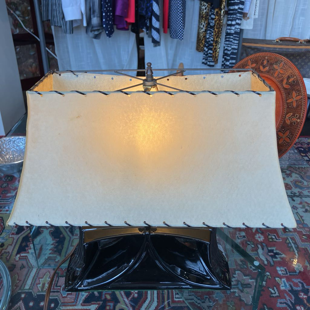 Mid-century lamp with a black ceramic angular base and a larger trapezoidal shade in a store setting. 