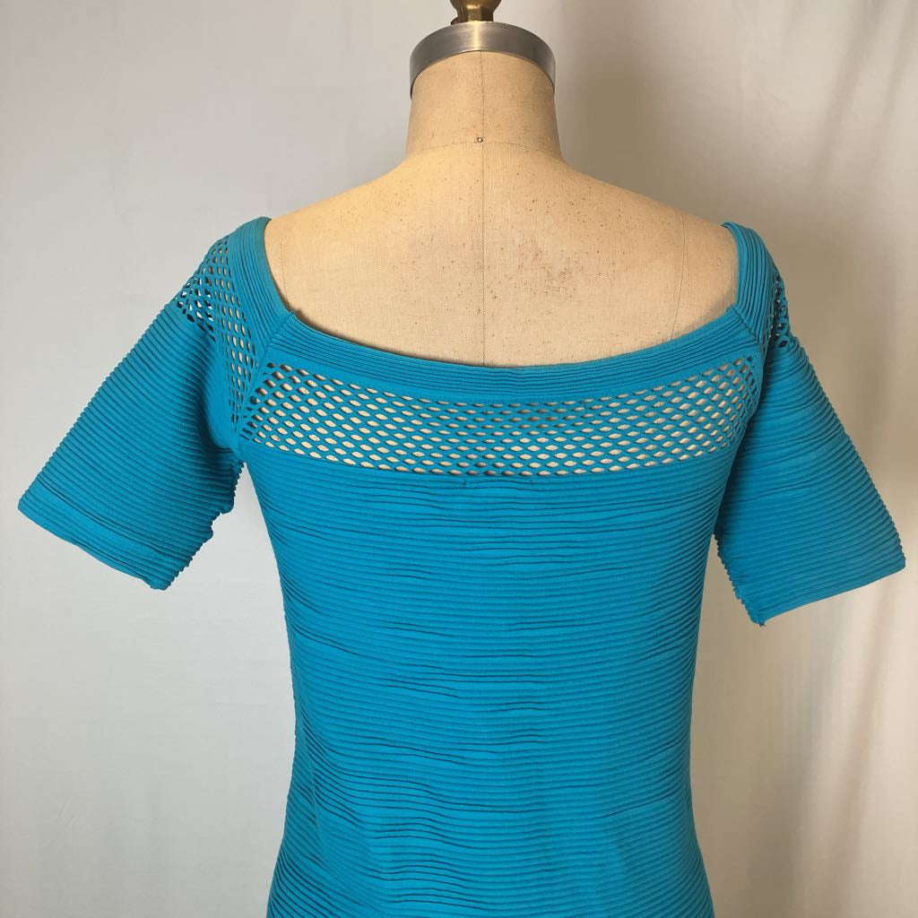 A bright turquoise blue short-sleeve top with a wide scoop neckline and a mesh cutout across the upper back, displayed on a beige dress form against a light neutral background.