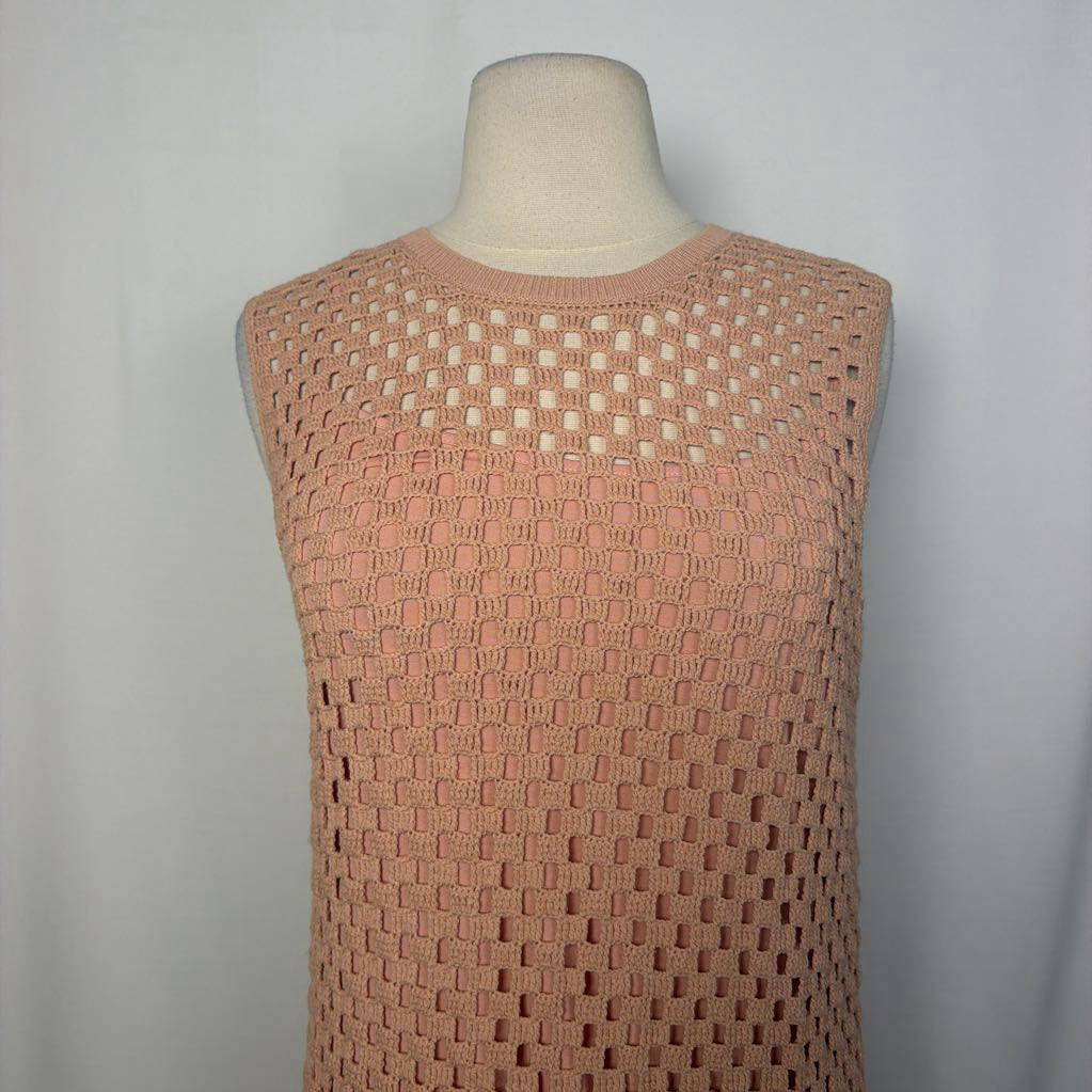 A sleeveless knit top in a dusty peach-pink color, displayed on a beige dress form mannequin against a light gray background.