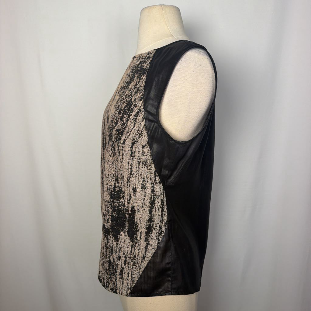 A black and white abstract sleeveless top on a mannequin in front of a white wall. 