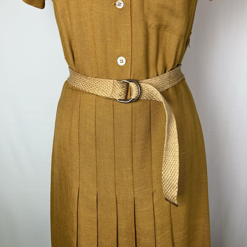 A close-up of a mustard yellow textured dress with a matching woven beige belt featuring a silver-tone metal ring buckle, shown on a mannequin against a plain light background.