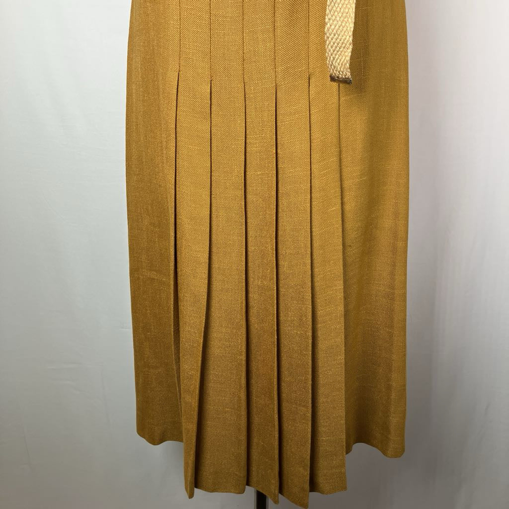 A mustard yellow pleated skirt displayed on a mannequin against a light gray background.