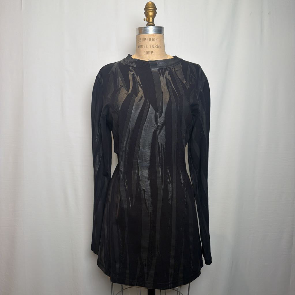 A black sheer long-sleeve tunic top displayed on a dress form mannequin against a white fabric backdrop.