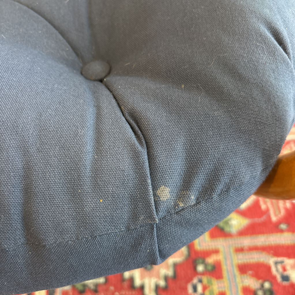 A small stain on a navy blue cushion. 