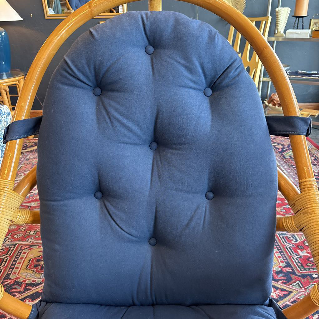 A blue cushion on a rattan frame in a room setting. 
