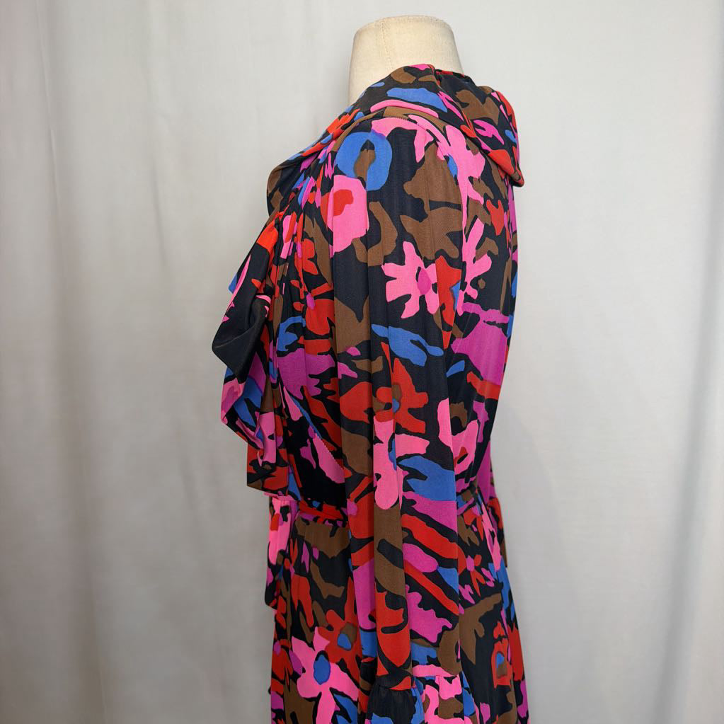 A multicolor abstract floral print dress displayed on a cream mannequin torso against a light gray fabric backdrop.