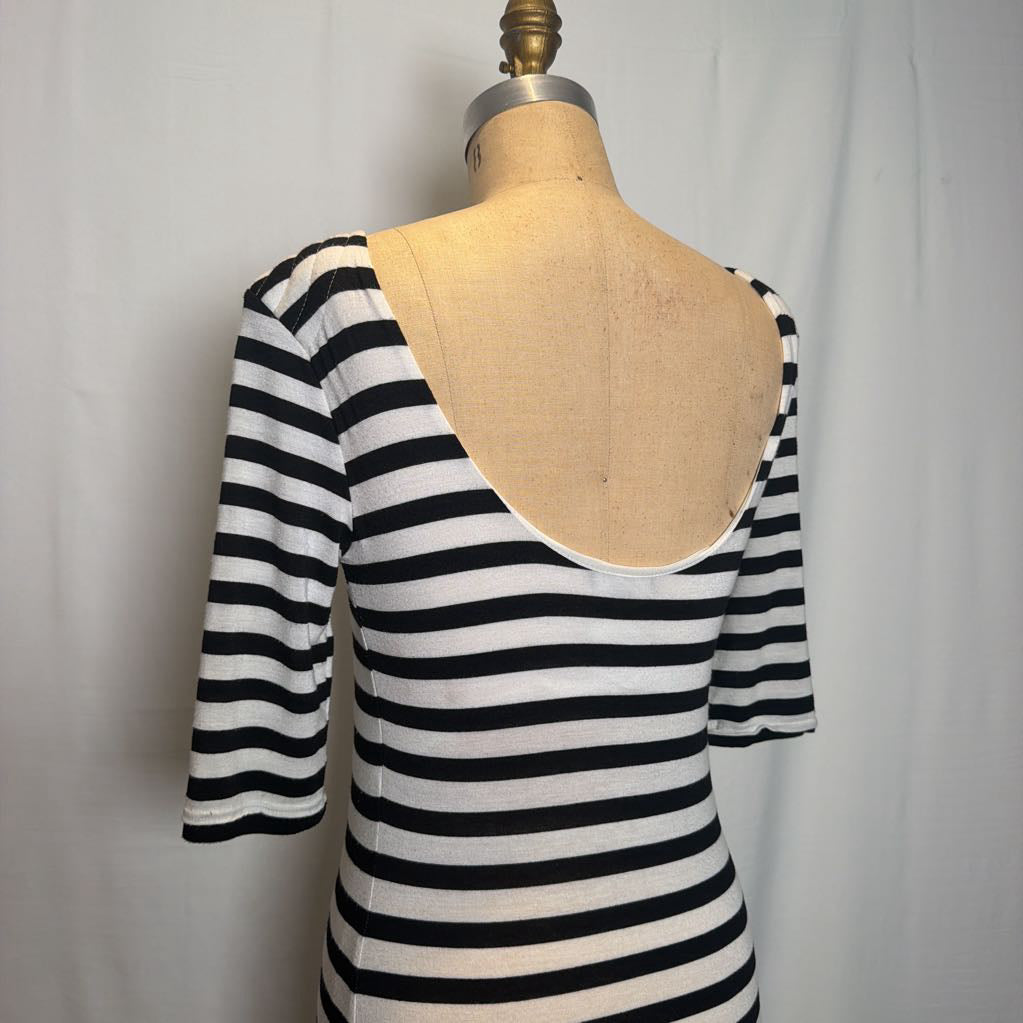 A black and white horizontally striped short-sleeve top displayed on a tan dress form against a light gray fabric backdrop.