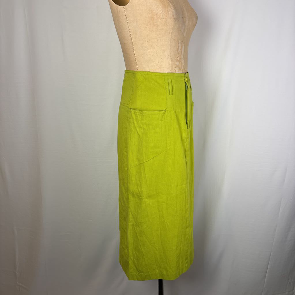 A bright lime green linen midi skirt displayed on a beige dress form mannequin against a white fabric backdrop.