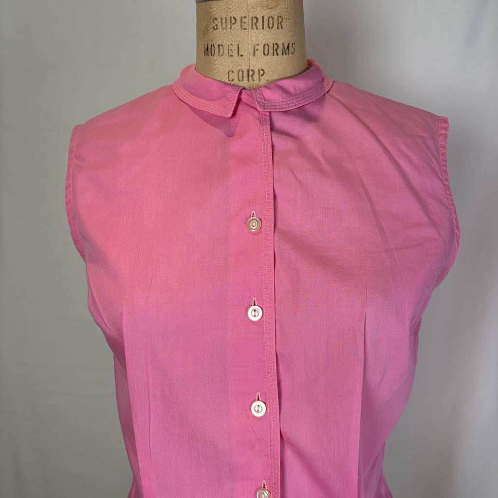 A sleeveless pink button-front blouse with a pointed collar, displayed on a vintage mannequin torso against a plain light background.