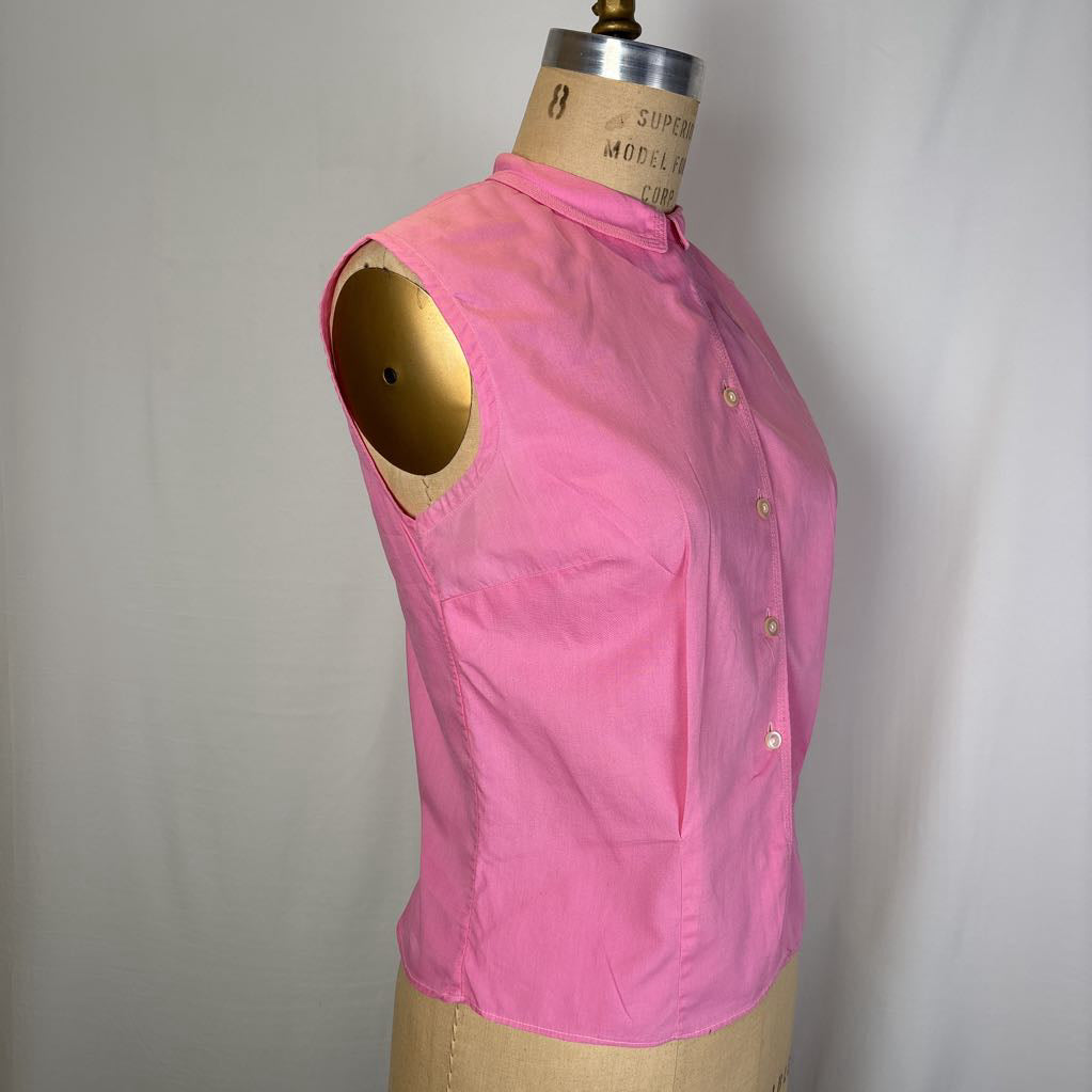 A bright pink sleeveless button-front top displayed on a tan dress form mannequin against a light gray fabric backdrop.